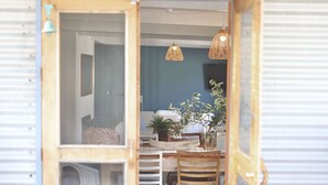 A cozy interior with a dining table, chairs, a hanging light fixture, and a potted plant. - MAISIES ROBE - WI-FI - DOG FRIENDLY (Robe)