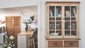 A kitchen with wooden cabinets, a countertop, and a stool. - MAISIES ROBE - WI-FI - DOG FRIENDLY (Robe)