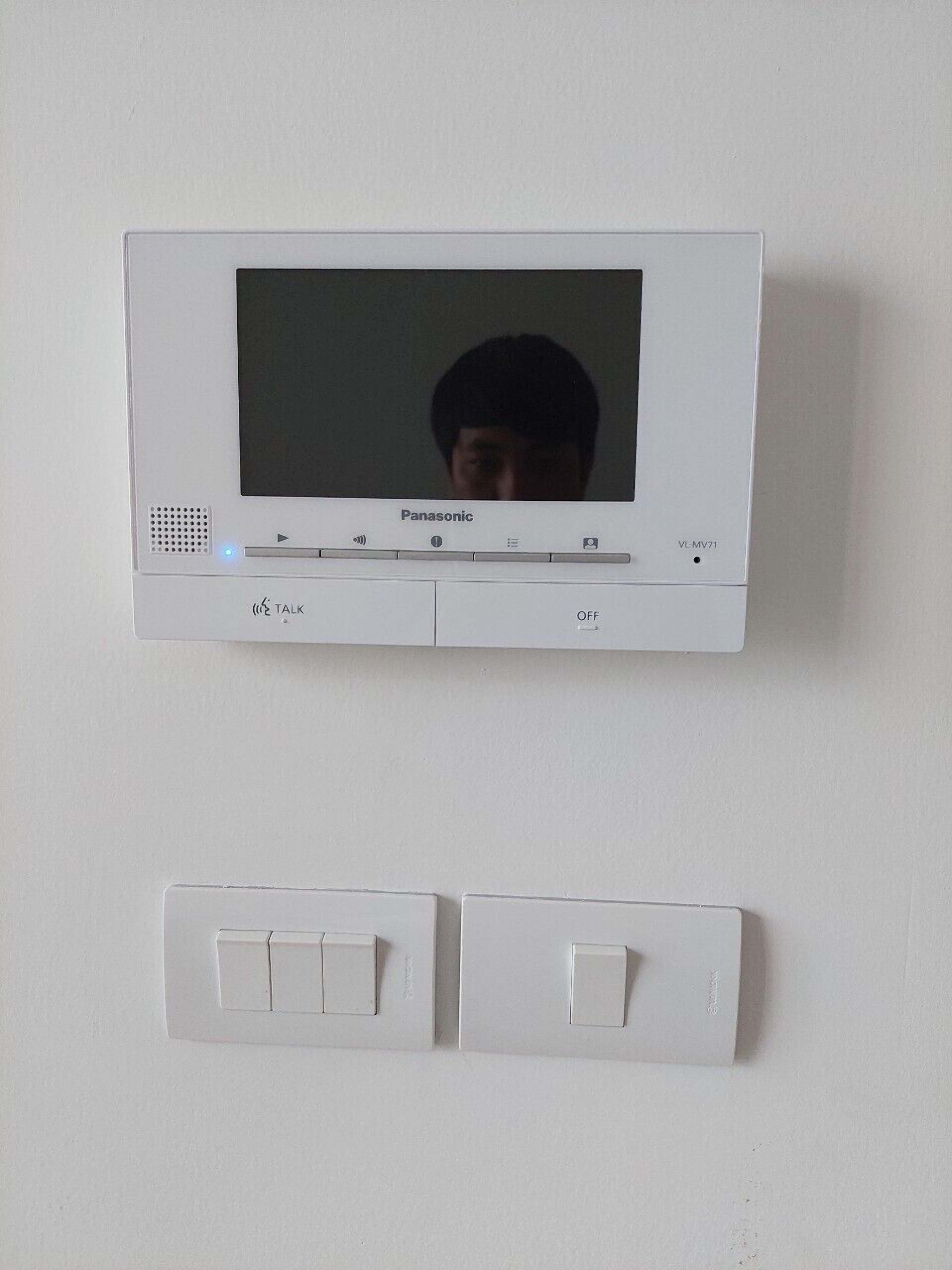 A Panasonic wall-mounted television with a remote control below it.