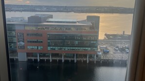 A waterfront view with a modern building, a dock, and a marina.