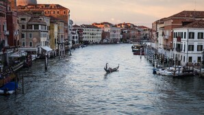 A canal in Venice with a gondola, historic buildings, and a dome in the background. - Hotel Palazzina Sardi (Venice)
