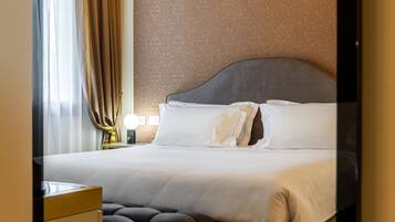 A neatly made bed with white linens and a dark headboard in a hotel room.