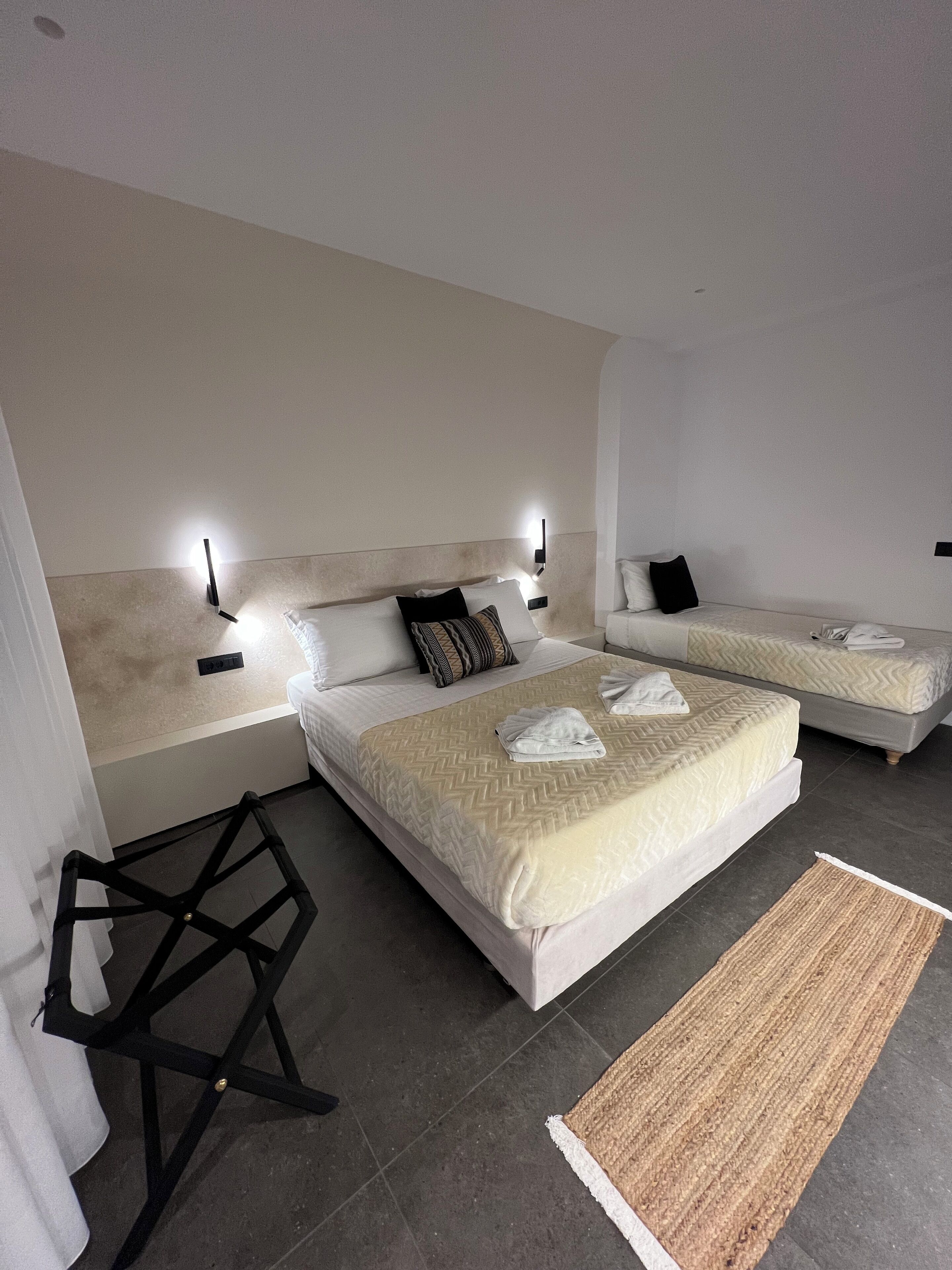 Habitación de hotel con dos camas, una mesita y una alfombra.