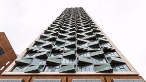 A tall building with a modern design, featuring a series of geometric patterns and large windows.