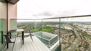 A balcony with a view of a cityscape, including roads and buildings.