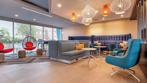 A modern lounge area with seating, tables, and decorative lighting.