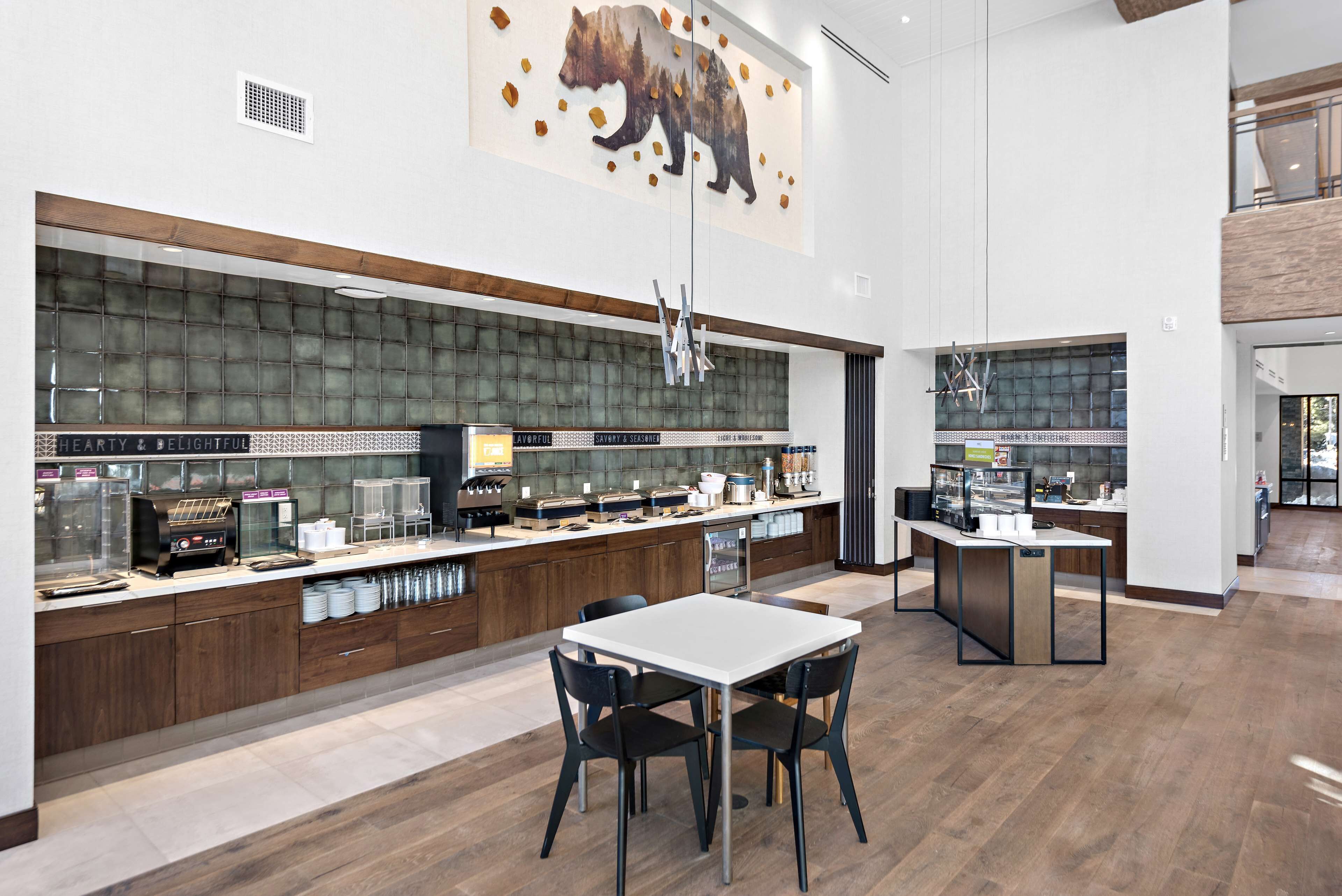 A modern kitchen with a large island, wooden cabinets, and a bear mural.