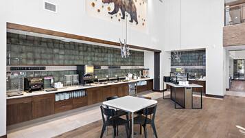 A modern kitchen with a large island, wooden cabinets, and a bear mural.