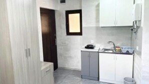 A compact kitchen with white cabinets, a sink, and a small countertop. - Modern, brand new rental unit,
Lovelv studio (Yerevan)