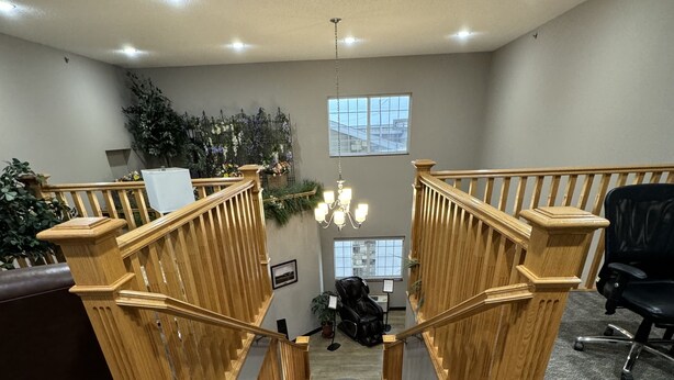 A staircase with wooden railings leading to a lower level. - Garner Inn & Suites (Garner)