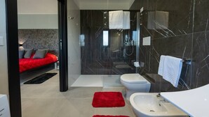 A modern bathroom with a shower, toilet, and bidet. - One-room Apartment "Suite Love" with View (SCARLINO)