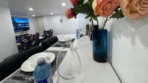 A hotel dining area with a long table set for two, a blue vase with roses, and a television displaying a game show. -
Pvt Studio near Fairway Mall & Waterloo Airport. Downtown in few minutes (Kitchener)