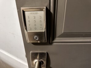 A door lock with a numeric keypad and a keyhole.