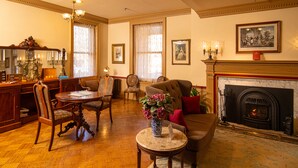 A traditional living room with a fireplace, wooden furniture, and a chandelier. - The Lafayette Inn (Easton)