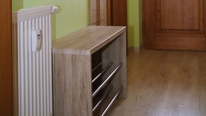 A hallway with a wooden door, a radiator, and a painting on the wall.