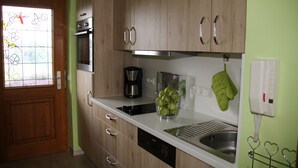A kitchen with wooden cabinets, a stainless steel sink, a dishwasher, and a coffee maker.