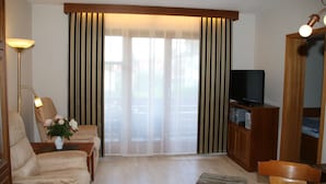 A living room with a sofa, a TV, and a wooden cabinet.