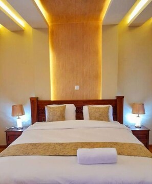 Relax in comfort with a large bed, two bedside tables, and warm recessed lighting.