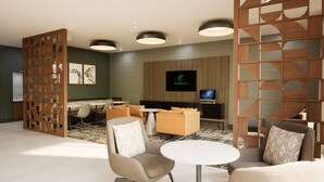 Eine moderne Hotelhalle mit Sitzgelegenheit, Fernseher und dekorativer Holzvertäfelung.