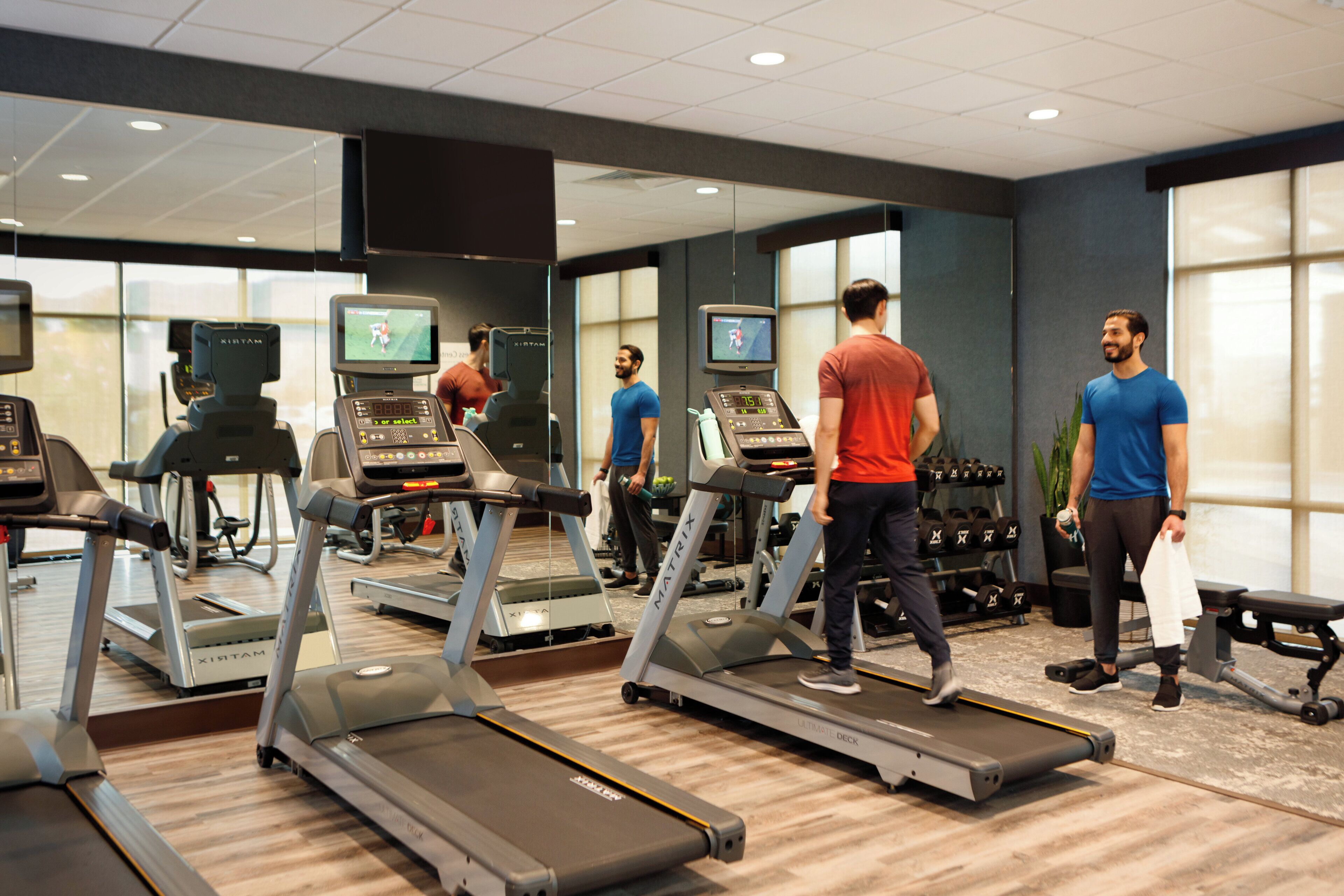 A gym with treadmills, weights, and exercise equipment.