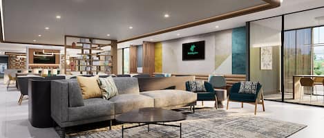 A modern hotel lobby with a sofa, chairs, a coffee table, and a reception desk.