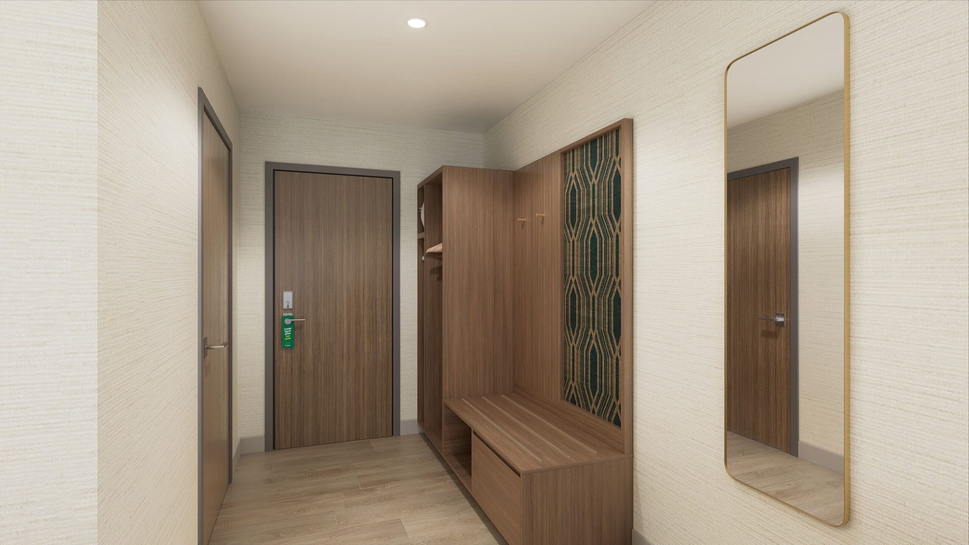 Un pasillo con una puerta de madera, un banco y un espejo en la pared.