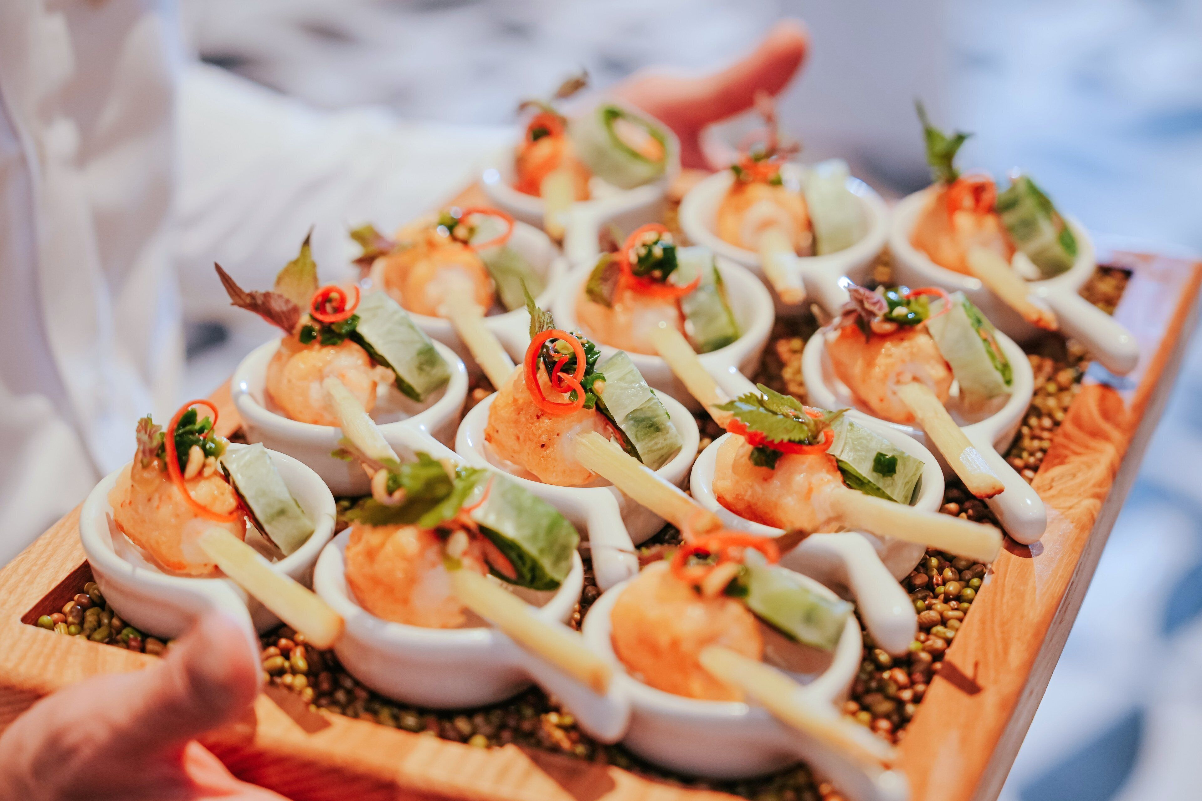 A tray of shrimp skewers garnished with herbs and vegetables.