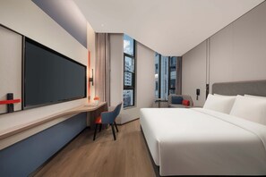 A modern hotel room with a large bed, a desk with a chair, a TV, and a window with a city view. - Holiday Inn Express Shanghai Hongqiao NECC by IHG (Shanghai)