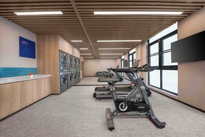 A gym with stationary bikes, a treadmill, and a wall-mounted TV. - Holiday Inn Express Shanghai Hongqiao NECC by IHG (Shanghai)