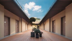 A corridor with wooden flooring, potted plants, and doors on both sides. - Holiday Inn Express Shanghai Hongqiao NECC by IHG (Shanghai)