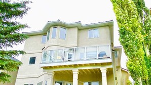 A two-story house with a balcony, large windows, and a well-maintained lawn. - Ravine House, 4000sqf, View, AC,Sleep12+

 (Calgary)