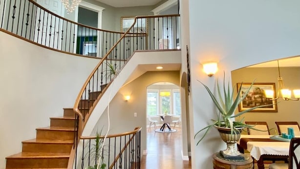 A spacious foyer with a grand staircase, wooden flooring, and a chandelier. - Ravine House, 4000sqf, View, AC,Sleep12+

 (Calgary)