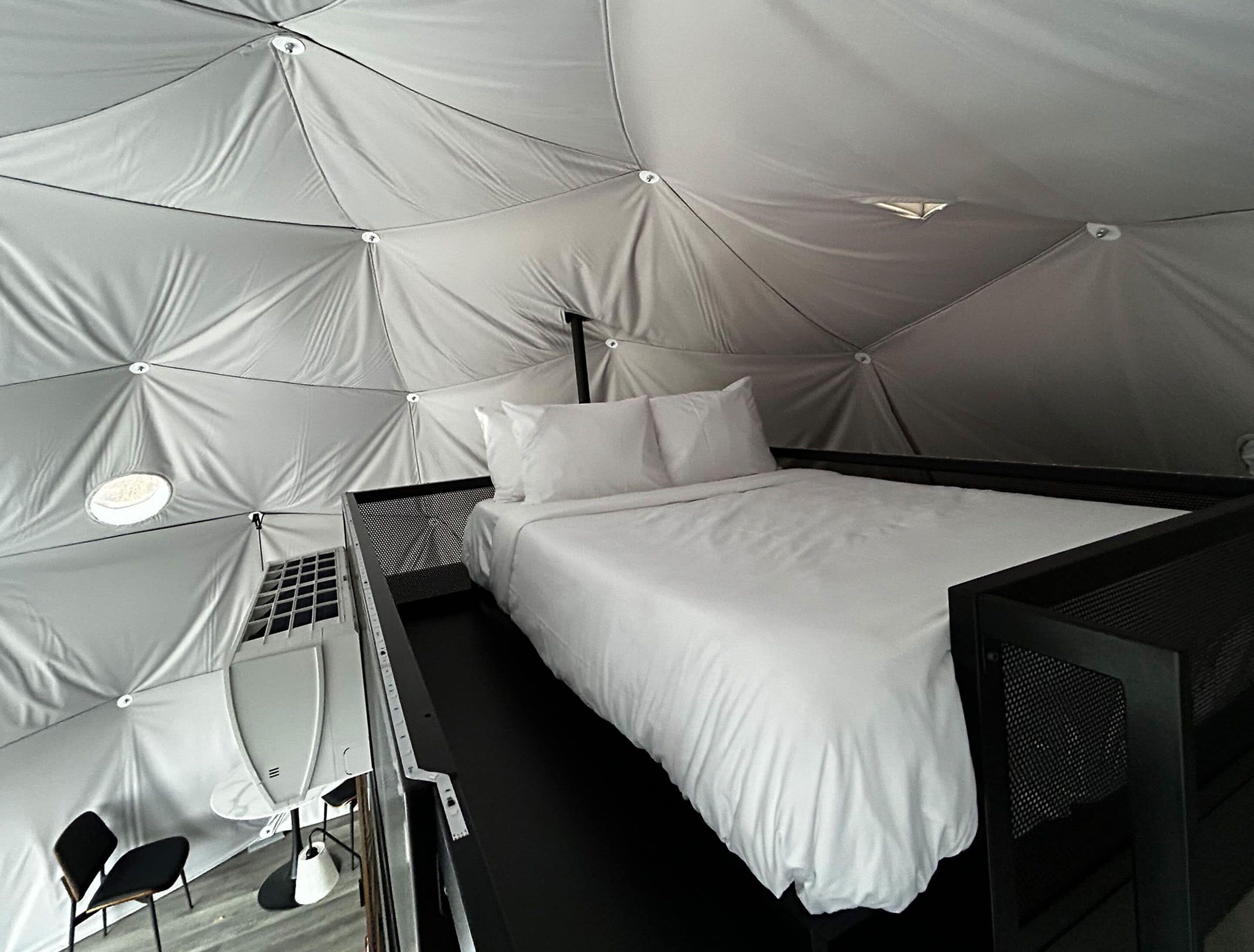 Una habitación compacta y moderna con cama, una mesita y una silla.