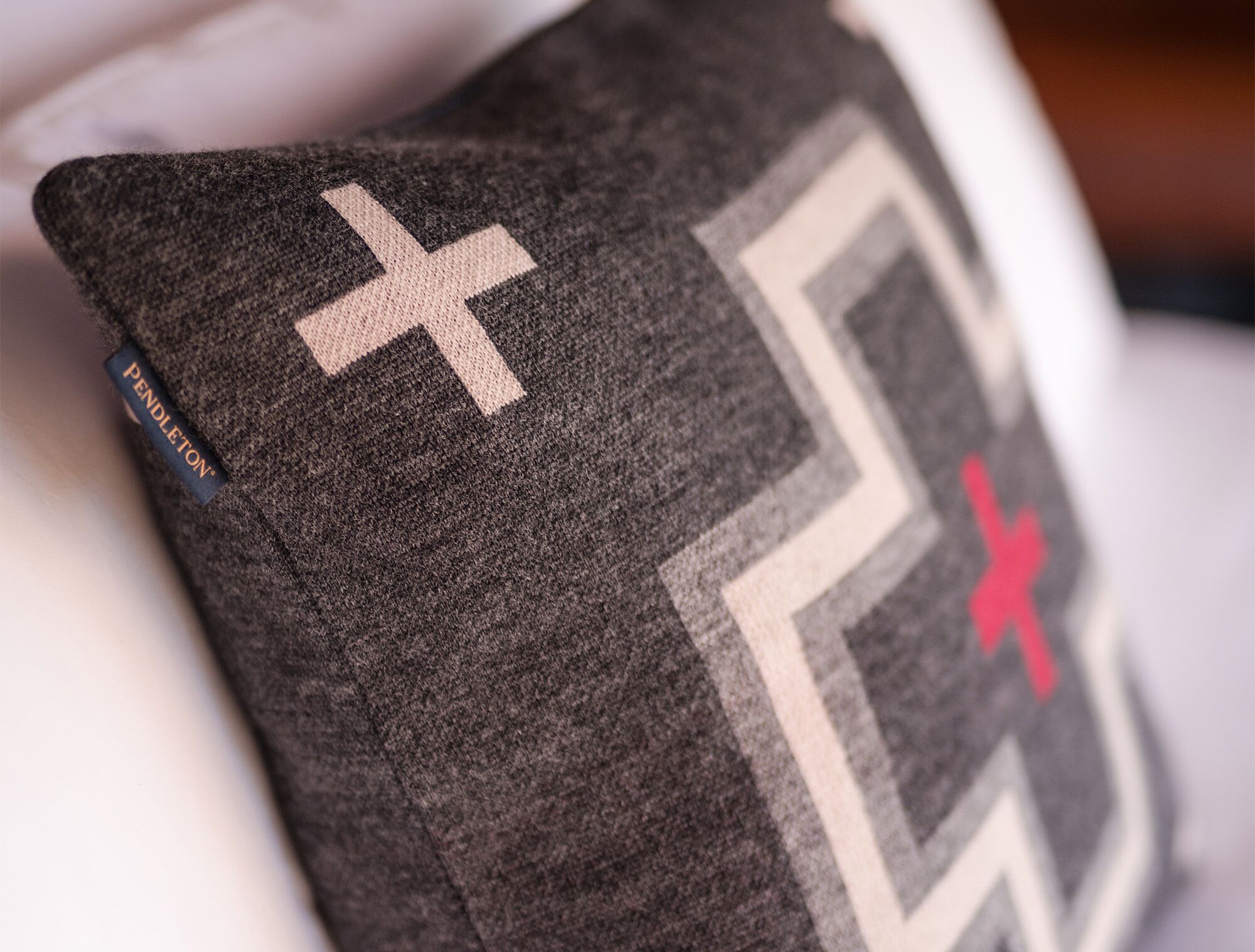 A pillow with a geometric pattern and a visible brand label.