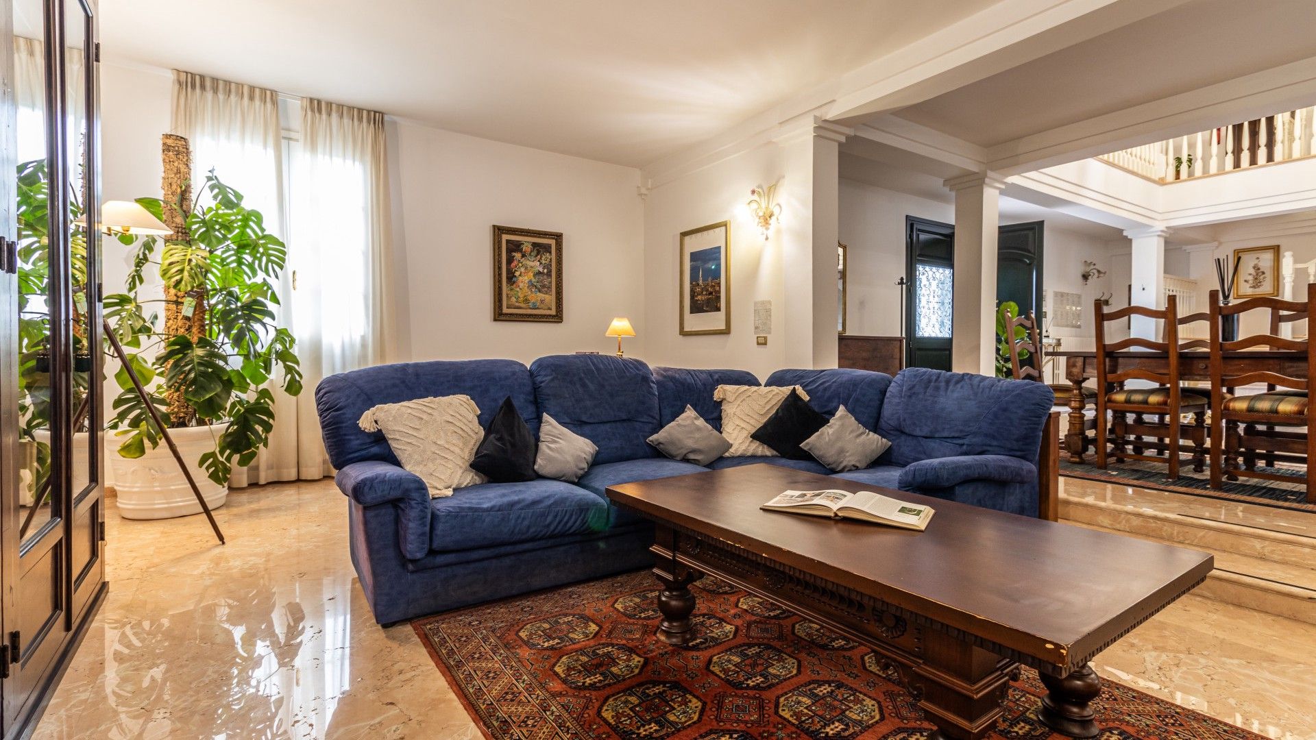 Un salon avec un canapé bleu, une table basse et un tapis à motifs.