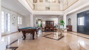 A spacious, well-lit room with a pool table, dining table, and chairs. - Villa Petrone | Luxury Four Seasons-Jacuzzi&Pool (Emilia-Romagna)