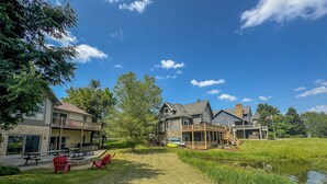 A residential area with houses, a grassy lawn, and a small pond.