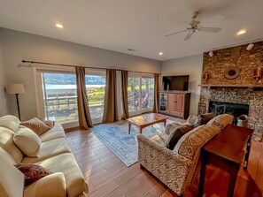 A spacious living room with a sofa set, a coffee table, and a fireplace. - Lakefront with dock, pickleball, renovated, Fab! (McHenry)