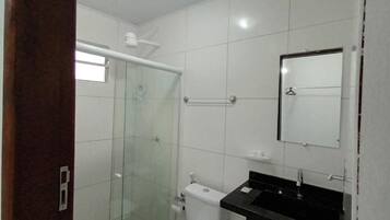 Chuveiro, toalhas de banho, sabonete, papel higiênico