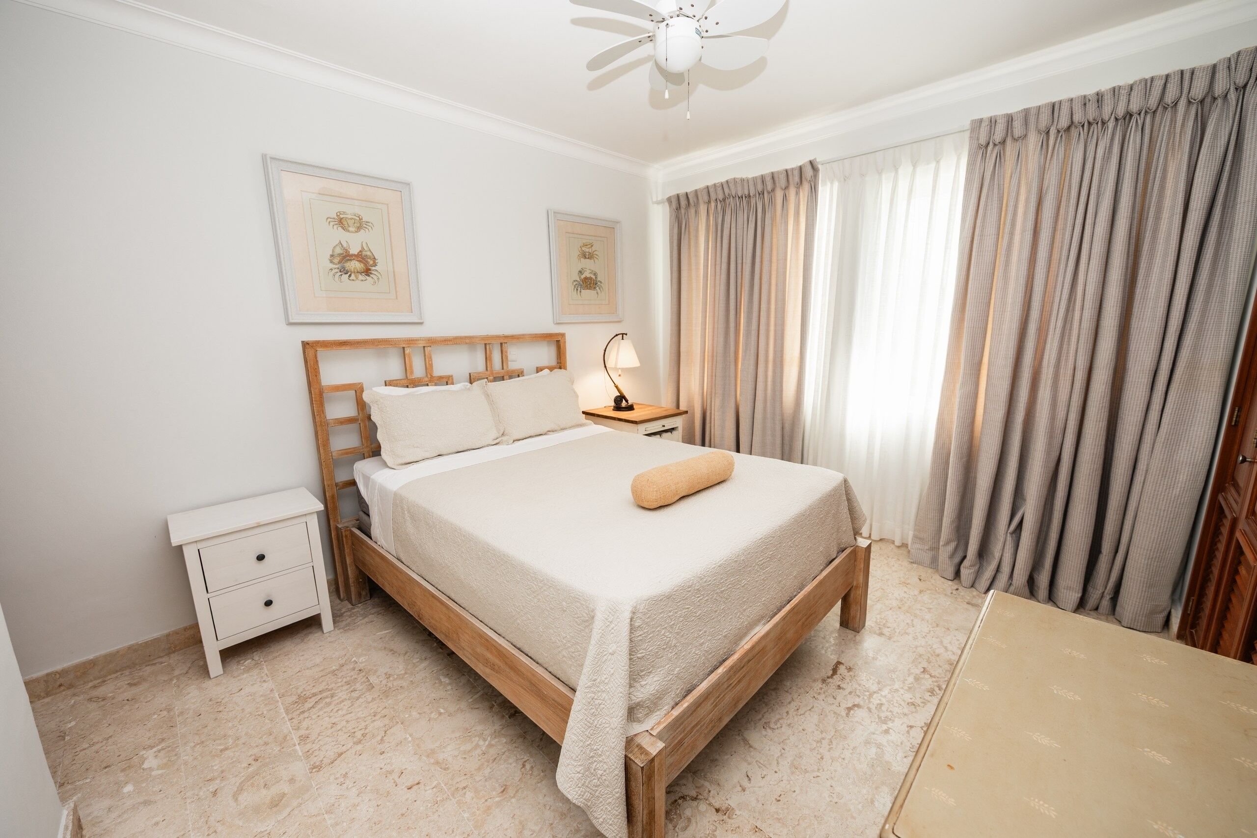 A neatly arranged bedroom with a wooden bed, a bedside table, and a nightstand.