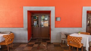 A restaurant with a checkered floor, wooden doors, and a sign indicating it's a hotel. - Voco Royalty Puebla Downtown (Puebla)