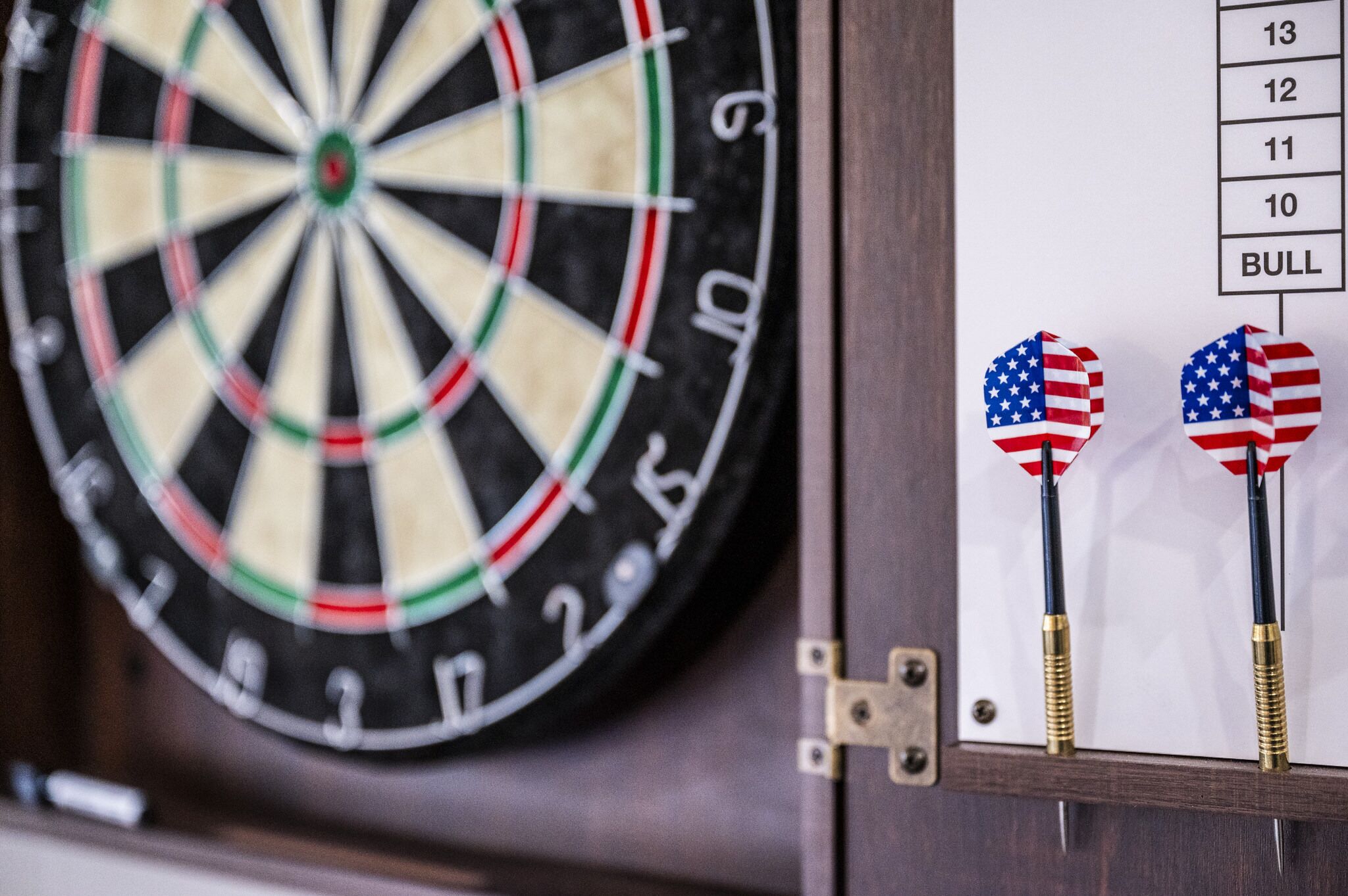 A dartboard with a dartboard and two American flag-themed darts.