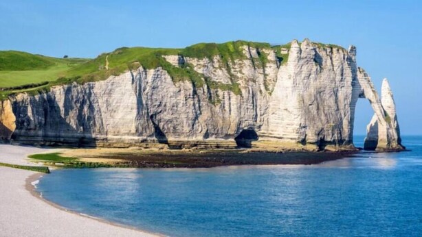 A coastal landscape with white cliffs and a clear blue sea. - Royal Rose (Étretat)