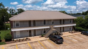 A two-story motel with a central staircase, a parking lot, and a satellite dish.