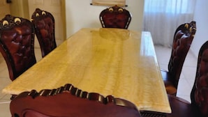 A dining room with a long table and six upholstered chairs. - 3 Bed House - Sleeps 9 - Pets - Garden - Parking (Accra)
