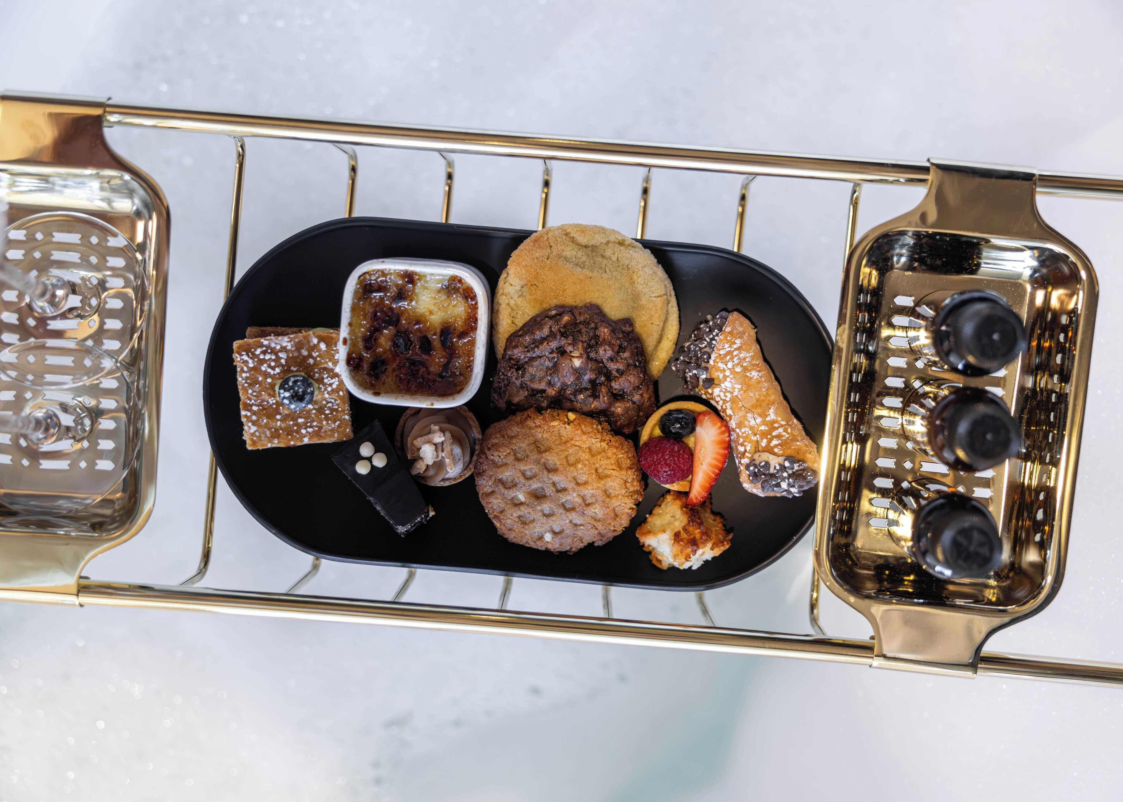 A tray with various food items including cookies, a chocolate bar, and a dessert.