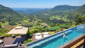 Una piscina con vistas a un valle y colinas.