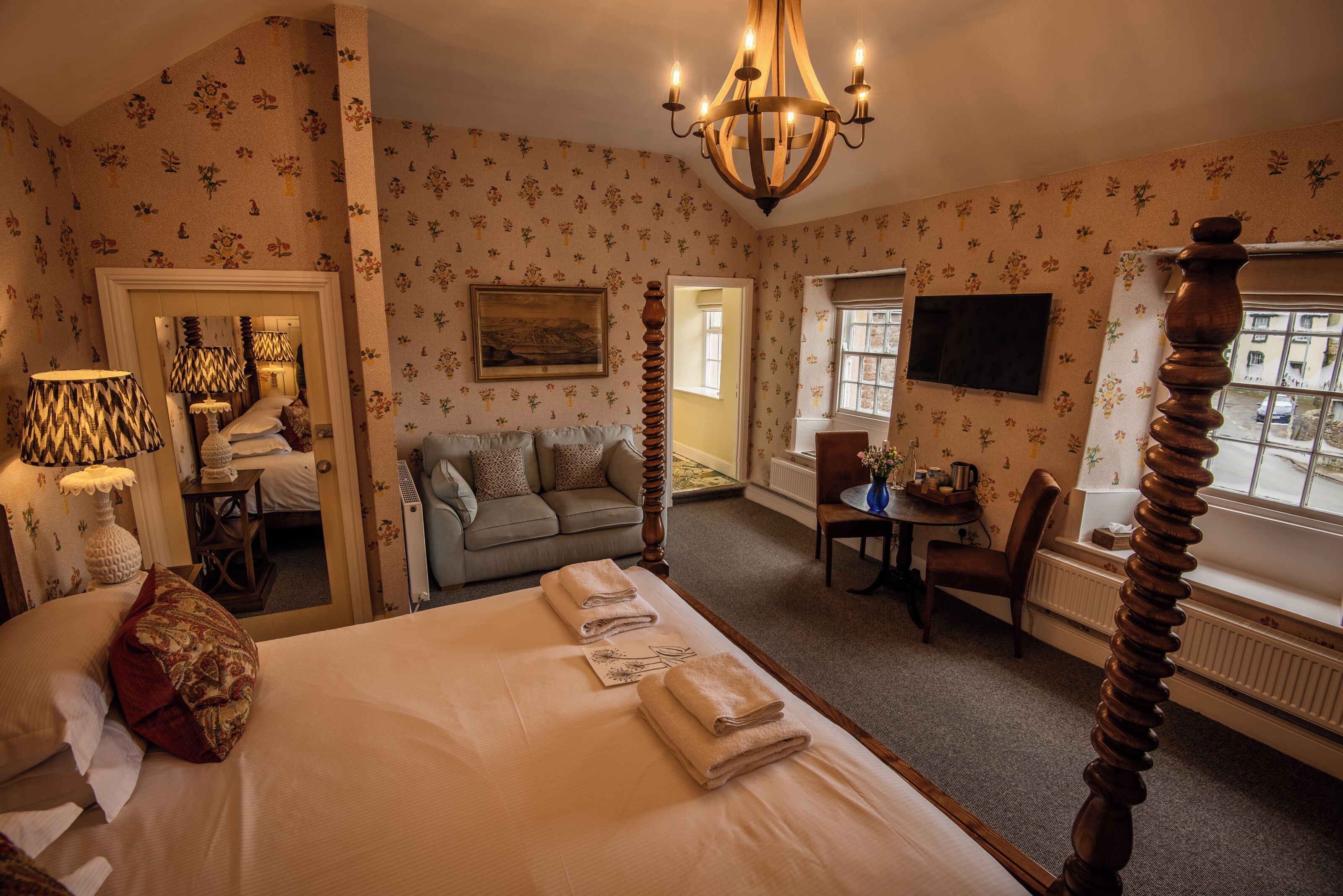 Une chambre d’hôtel avec un grand lit, un canapé, une table à manger et un téléviseur.