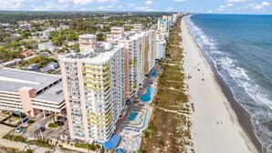 A coastal hotel with multiple high-rise buildings, a beach, and a swimming pool complex. - Baywatch Resort Incredible Oceanfront Family Dream Maker (North Myrtle Beach)