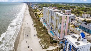 A coastal hotel with multiple buildings, a beach, and a swimming pool. - Baywatch Resort Incredible Oceanfront Family Dream Maker (North Myrtle Beach)